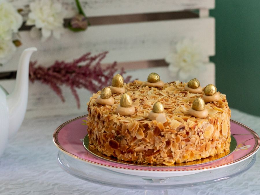 Goldene Nusscremetorte mit Mandelrand und goldenen Kugeln