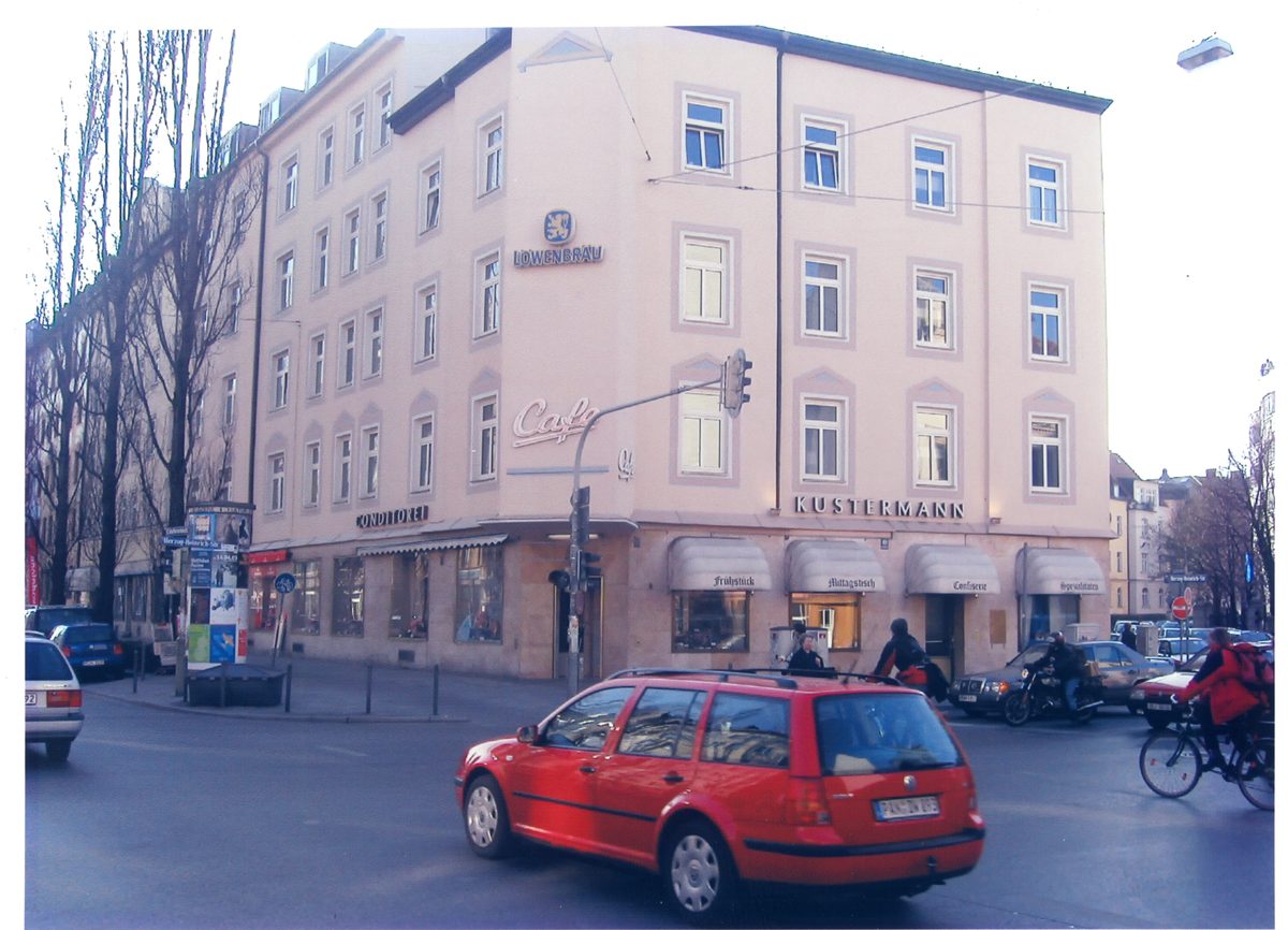 Das Haus in Rosa mit der Leuchtschrift Cafe über dem Eck und Markisen darunter